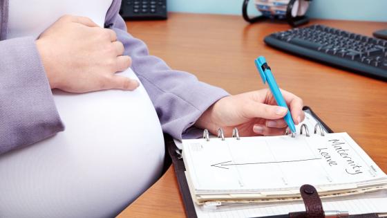 Pregnant woman adding maternity leave to diary